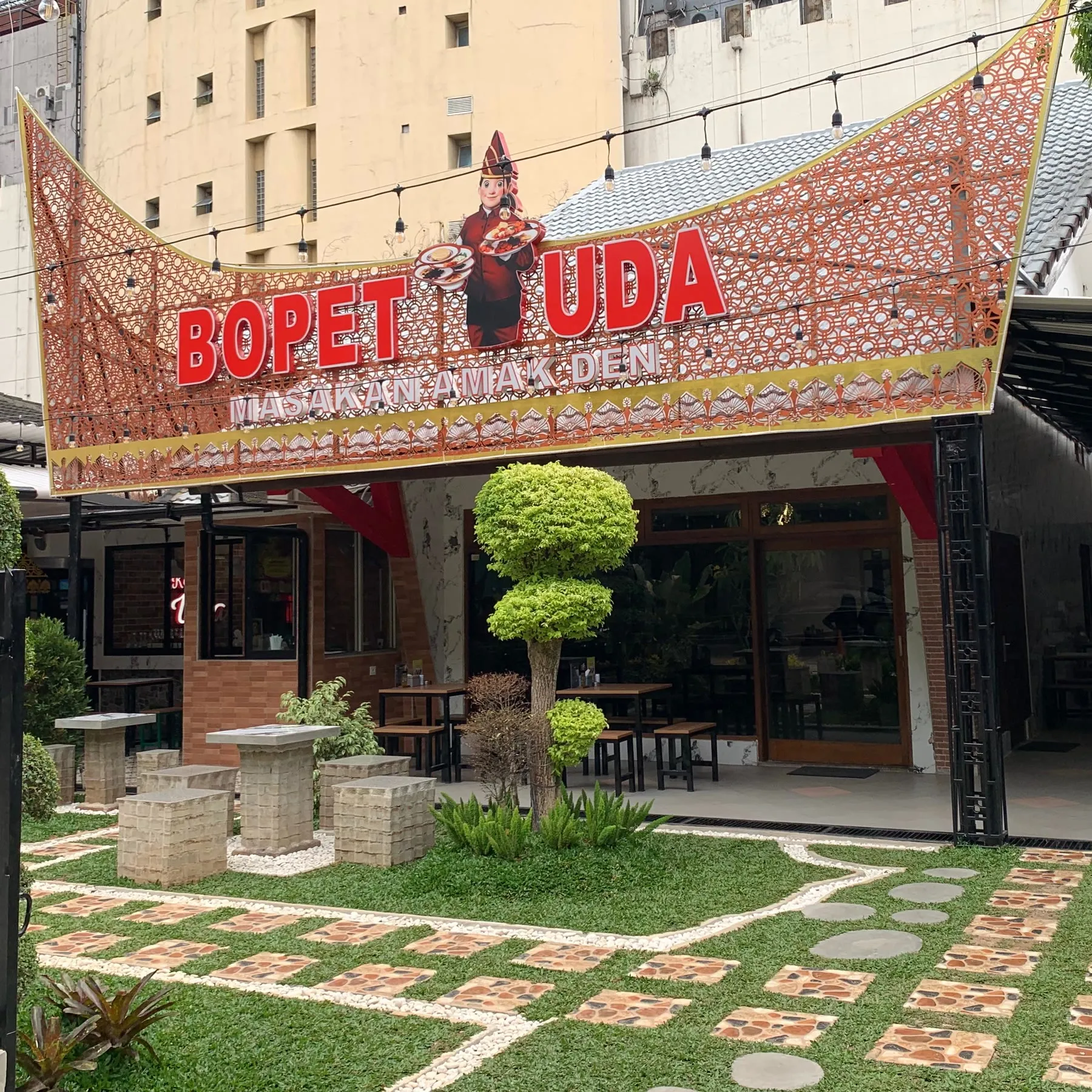 Tampak depan Bopet Uda dengan atap gonjong dan taman