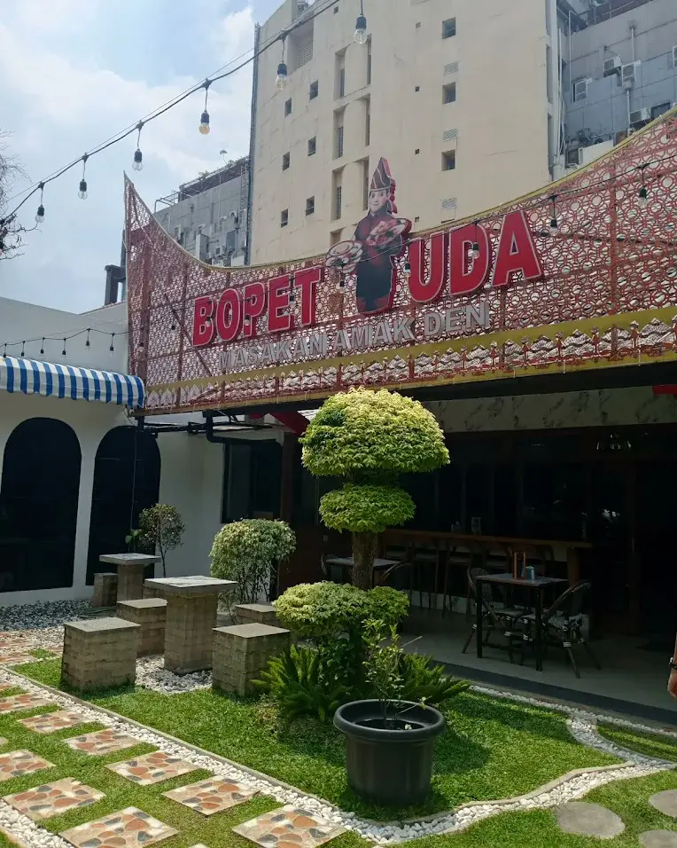 Atap gonjong Bopet Uda dan bangunan Baraso di tengah taman